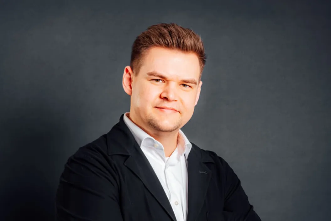 Geschäftsführer Henrik Hirte steht leicht seitlich zur Kamera und hat die Arme verschränkt.