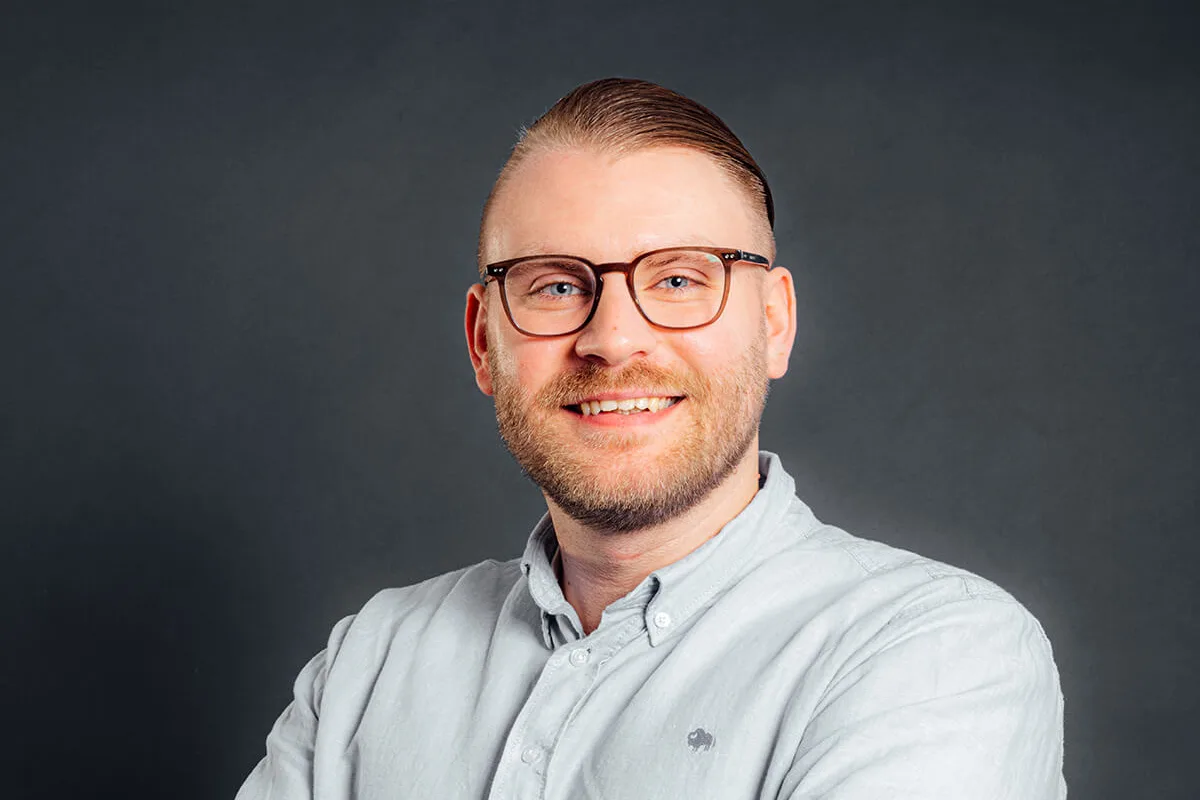 Informationstechniker und Change Manager Yannick Zirke steht leicht seitlich zur Kamera.