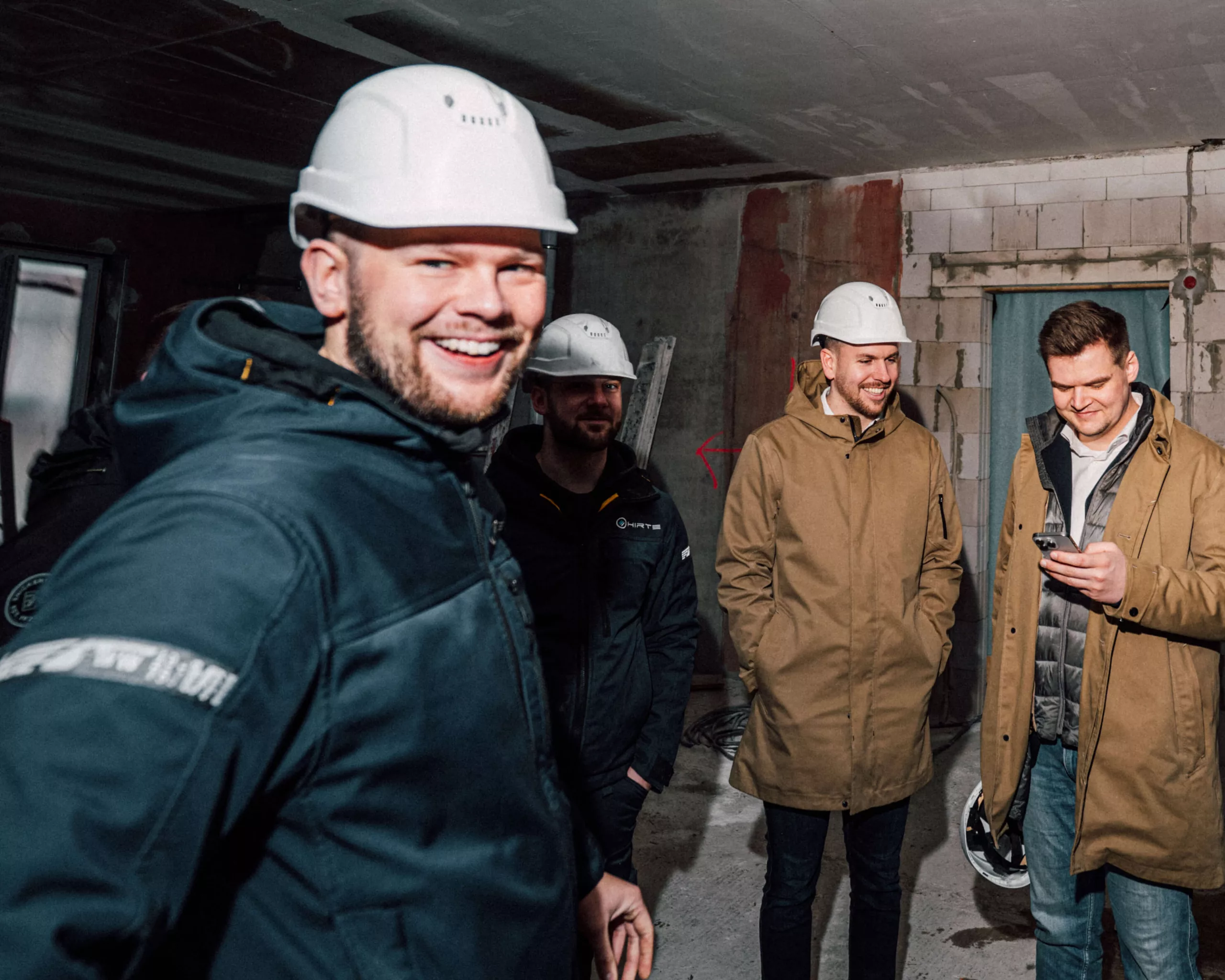 Mitarbeiter der Fite-Gruppe stehen auf der Baustelle eines Kunden und führen eine Besprechung.